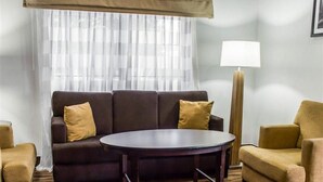 Un salon comprenant un canapé, une table basse ronde et un lampadaire.
