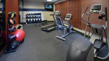 A gym with treadmills, exercise balls, and dumbbells.