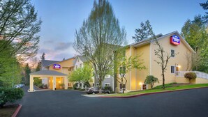 Un hotel Fairfield Inn & Suites con entrada cubierta, estacionamiento y césped bien cuidado.