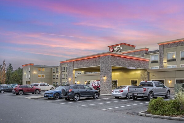 A Best Western Plus hotel with a parking lot and several vehicles. - Best Western Plus Peppertree Airport Inn (Spokane)