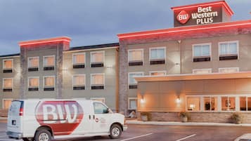 A Best Western Plus hotel with a parking lot and a van parked in front.