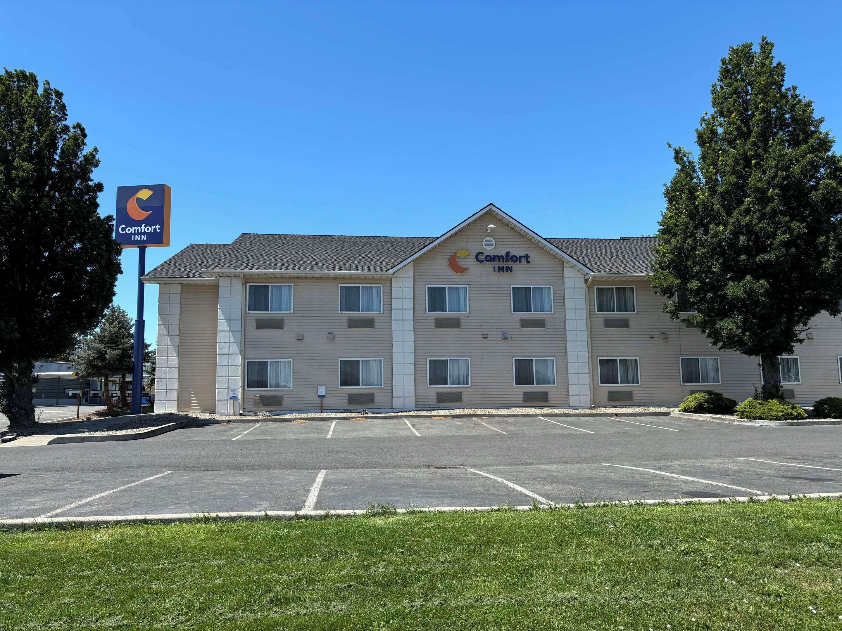 A Comfort Inn hotel with a parking lot and a grassy area in front.