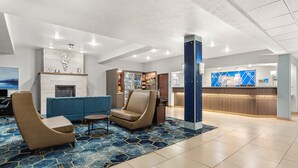 A lobby with a blue sofa, two armchairs, a fireplace, a reception desk, and a counter with a blue and white design. - Holiday Inn Express Wenatchee by IHG (Wenatchee)