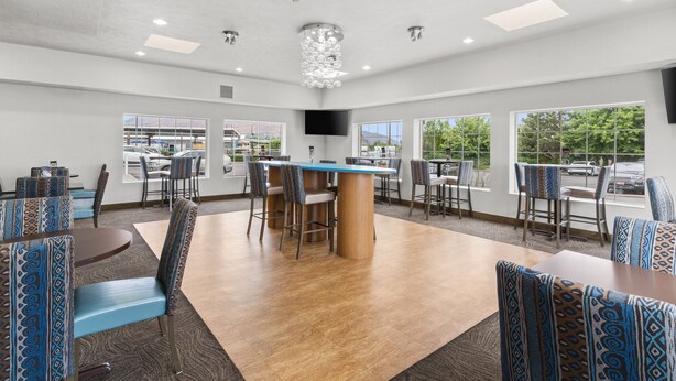 A spacious indoor area with a central bar, multiple seating arrangements, and large windows providing natural light. - Holiday Inn Express Wenatchee by IHG (Wenatchee)