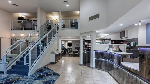 A spacious hotel lobby with a central staircase, a reception desk, and a dining area. - Holiday Inn Express Spokane-Valley by IHG (Spokane Valley)