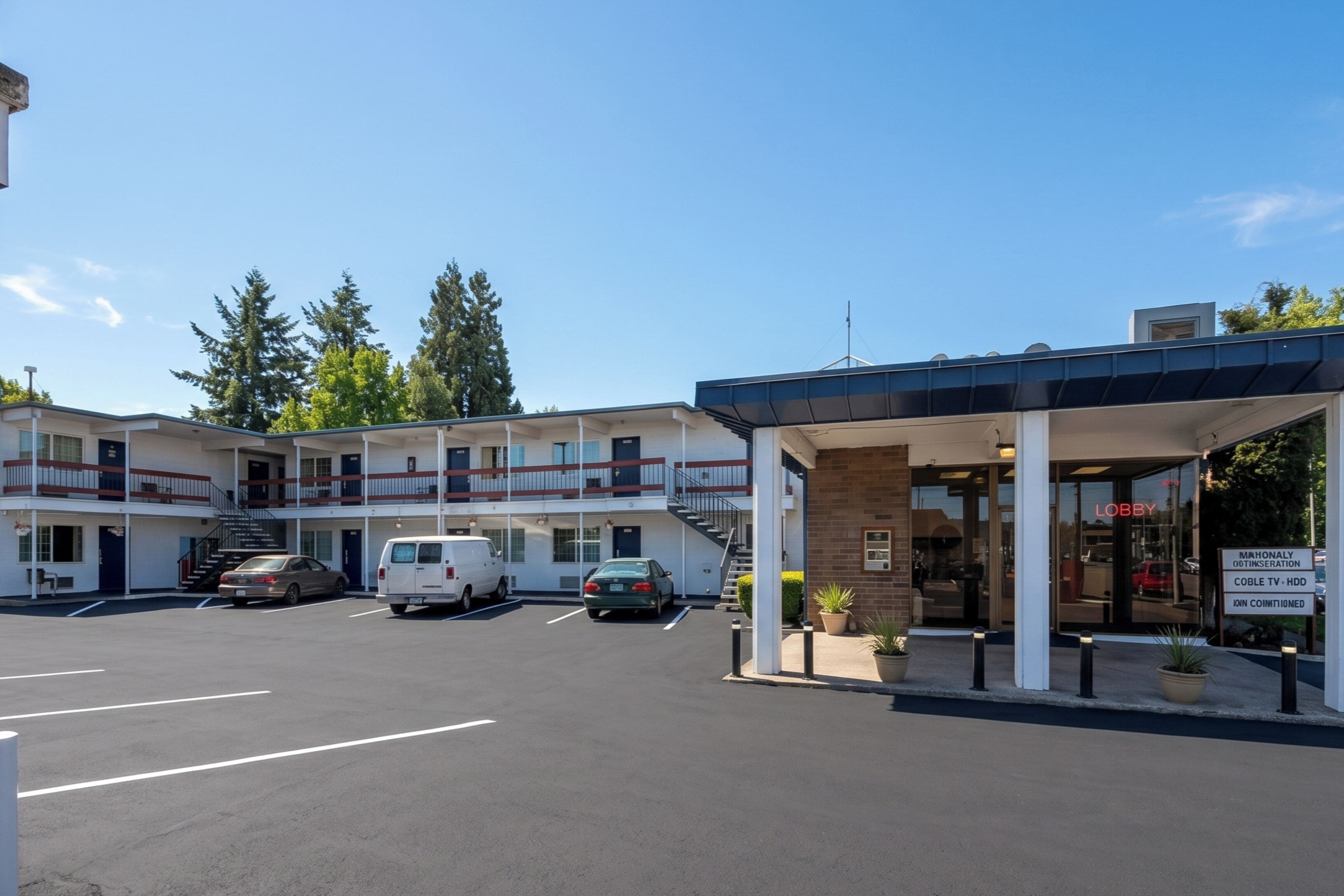 Un motel con entrada cubierta, varios pisos y estacionamiento.
