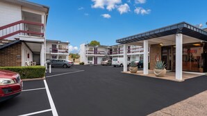 A multi-story hotel with a parking lot, a covered entrance, and a visible lobby area. - Travelers Inn by OYO Longview Kelso (Longview)