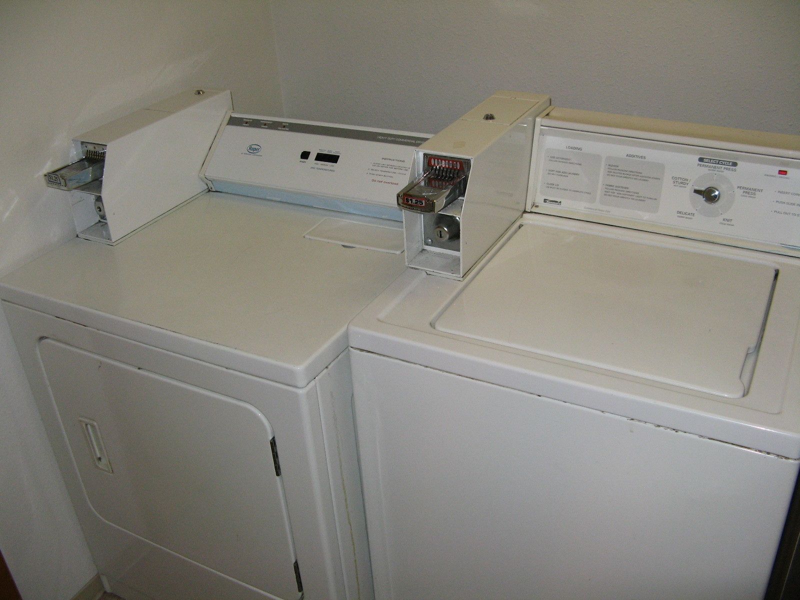 A laundry room with two stacked washers and dryers.