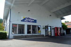 Un edificio con un letrero que dice 'Bellingham Lodge' y una máquina expendedora de Coca-Cola en el exterior.