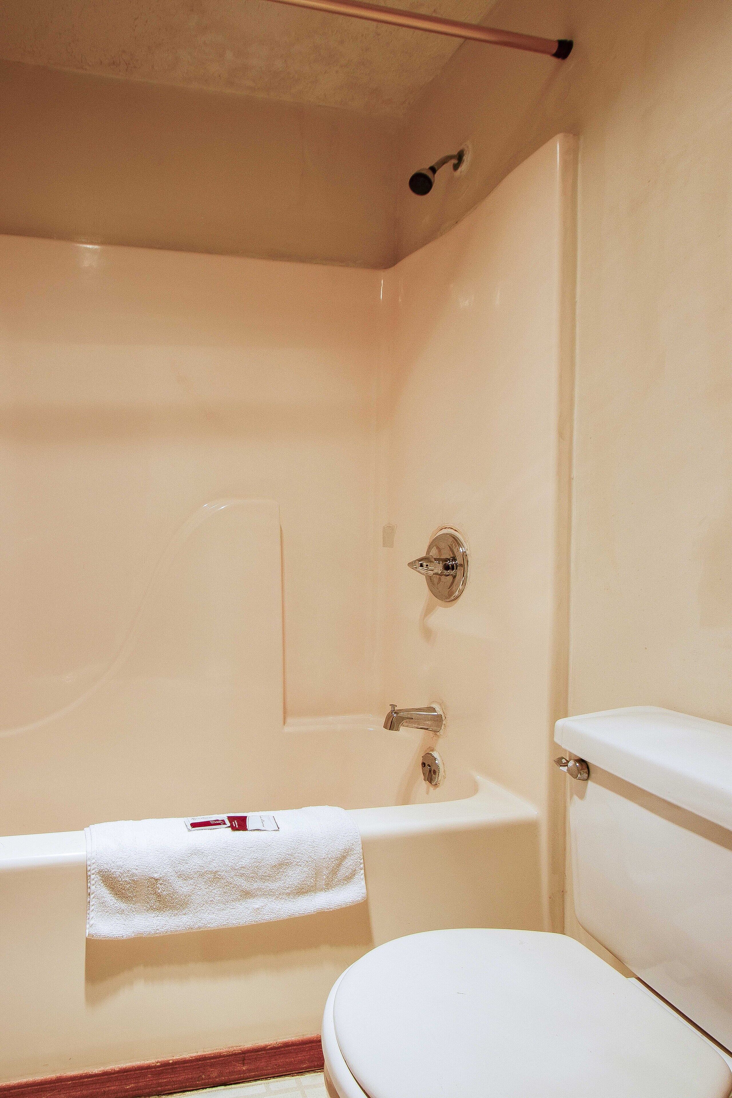 Un baño con bañera, inodoro y ducha.