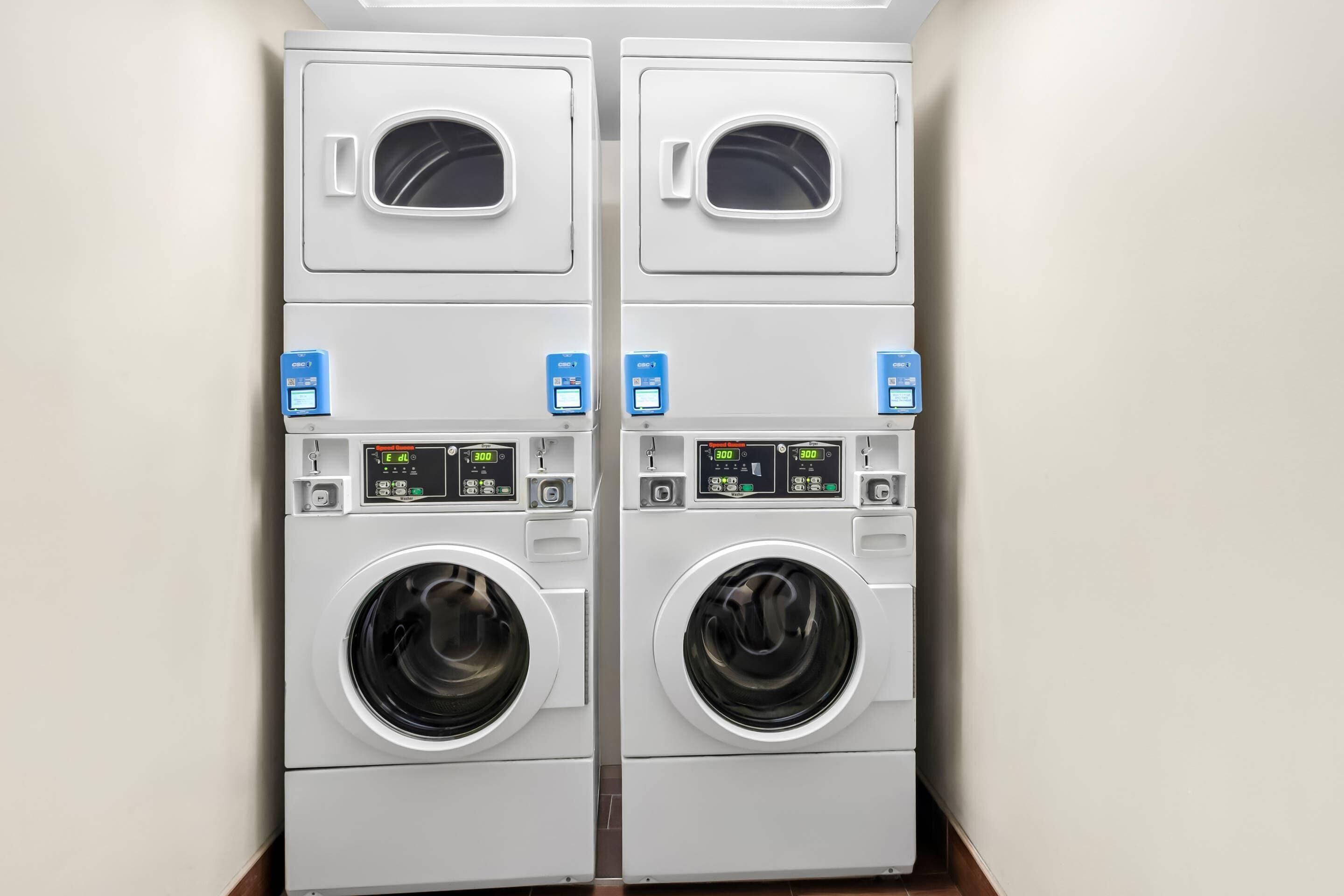 A pair of front-loading washing machines in a laundry room.