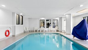 A swimming pool with white chairs and a red life ring on the wall. - Sleep Inn & Suites Princeton I-77 (Princeton)