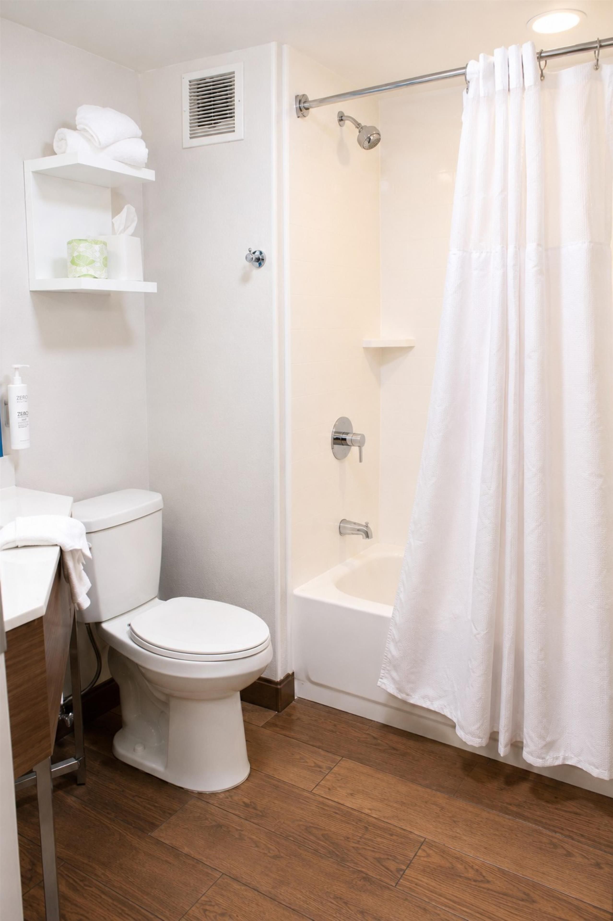Un baño con inodoro, ducha y lavamanos.