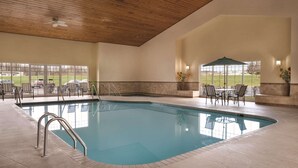 An indoor swimming pool with a wooden ceiling, clear glass windows, and outdoor seating area. - Country Inn & Suites by Radisson, Germantown, WI (Village of Germantown)