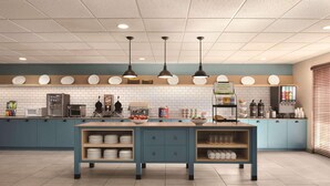 A modern kitchen with blue cabinets, a central island with a sink, and overhead pendant lighting. - Country Inn & Suites by Radisson, Germantown, WI (Village of Germantown)