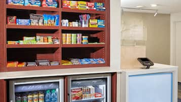 A self-service kiosk with a variety of snacks, including chips and cookies, and a refrigerated section with beverages.