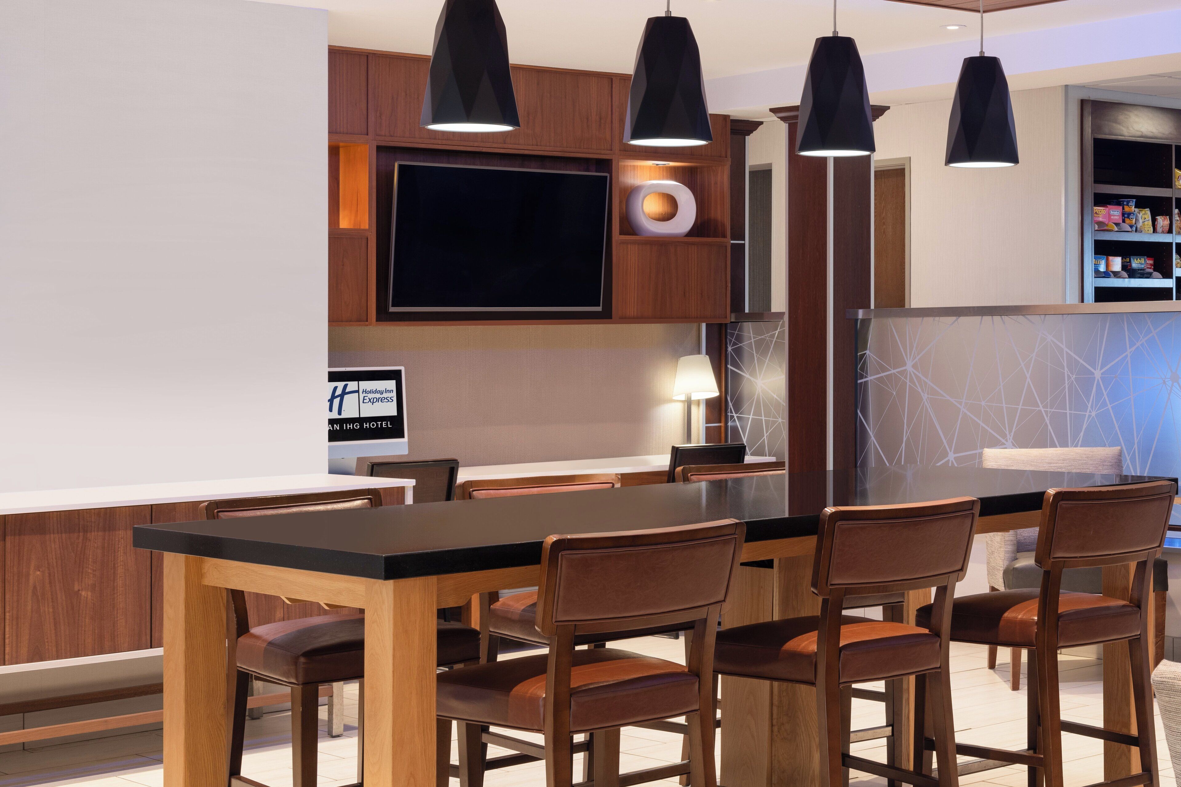 Una cocina moderna con una isla grande, armarios de madera y un televisor de pantalla plana.