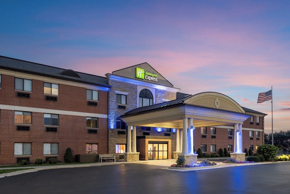 A Holiday Inn Express hotel with a brick facade, a covered entrance, and an American flag.
