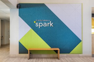 Una pared con diseños geométricos y el texto 'It only takes a spark'.