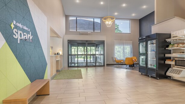 Eine moderne Lobby mit einer Holzbank, einer Sitzecke, einem Kühlschrank und einem großen Fenster.