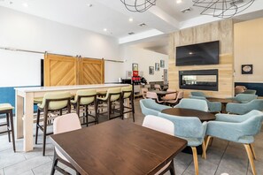 Café area with various seating options and a large wooden partition.