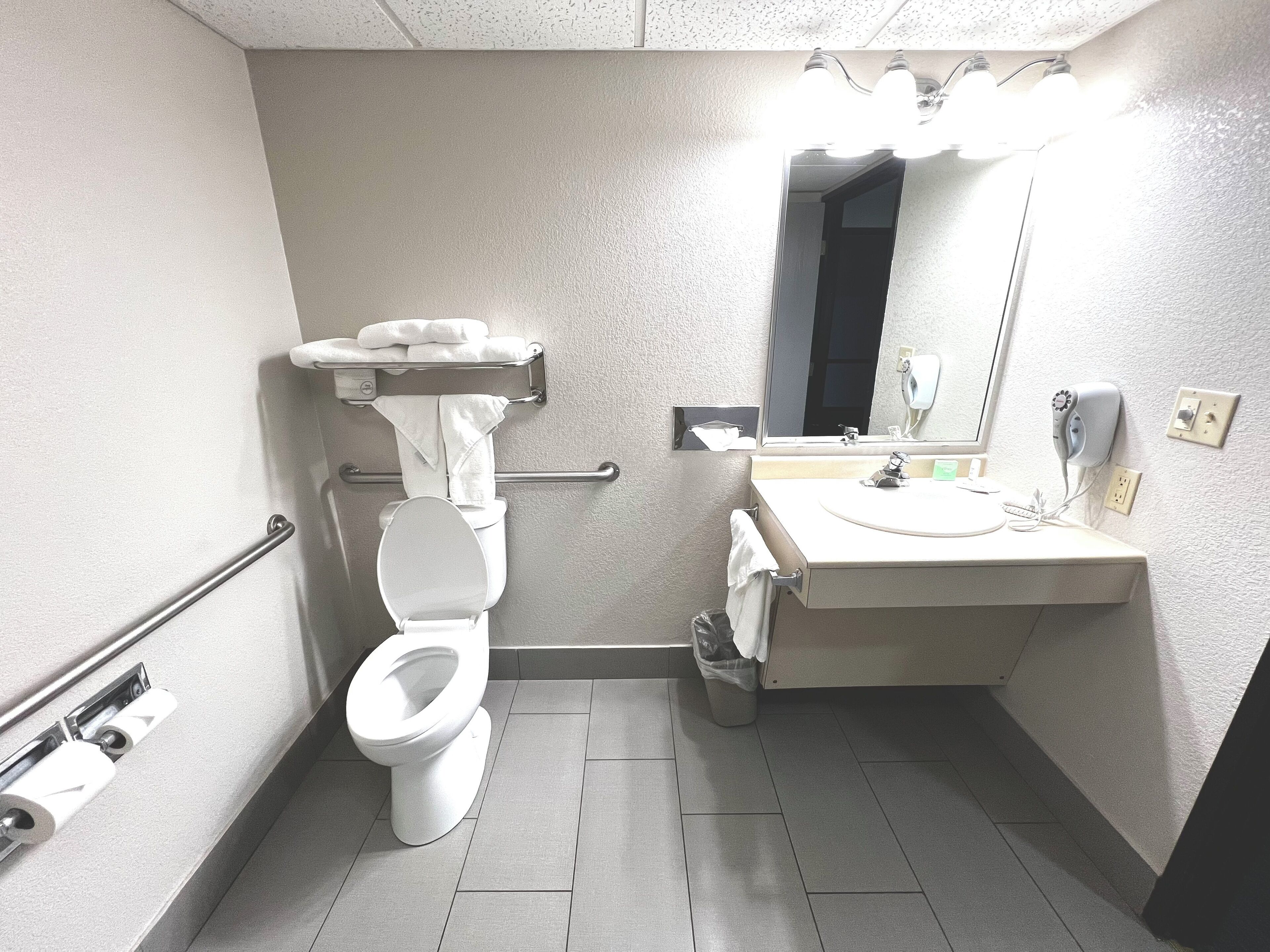 Une petite salle de bain moderne, équipée de toilettes, d’un lavabo et d’un miroir.