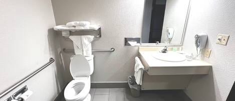 Un baño pequeño y moderno con inodoro, lavamanos y espejo.