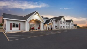 Un hotel con recepción, varias habitaciones y estacionamiento.