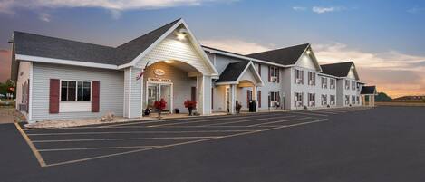 A hotel with a front desk, multiple rooms, and a parking lot.