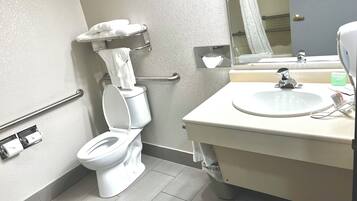 Un baño moderno con inodoro, lavamanos y espejo.