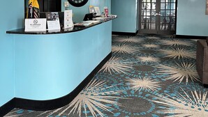 A reception area with a curved counter, a clock, and a 'No Smoking' sign. - Days Inn by Wyndham Neenah (Neenah)