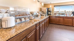 A breakfast buffet with various food items and a coffee station.