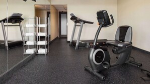 A fitness room with exercise equipment, a mirror, and a towel rack. - Days Inn by Wyndham Grand Island I-80 (Grand Island)