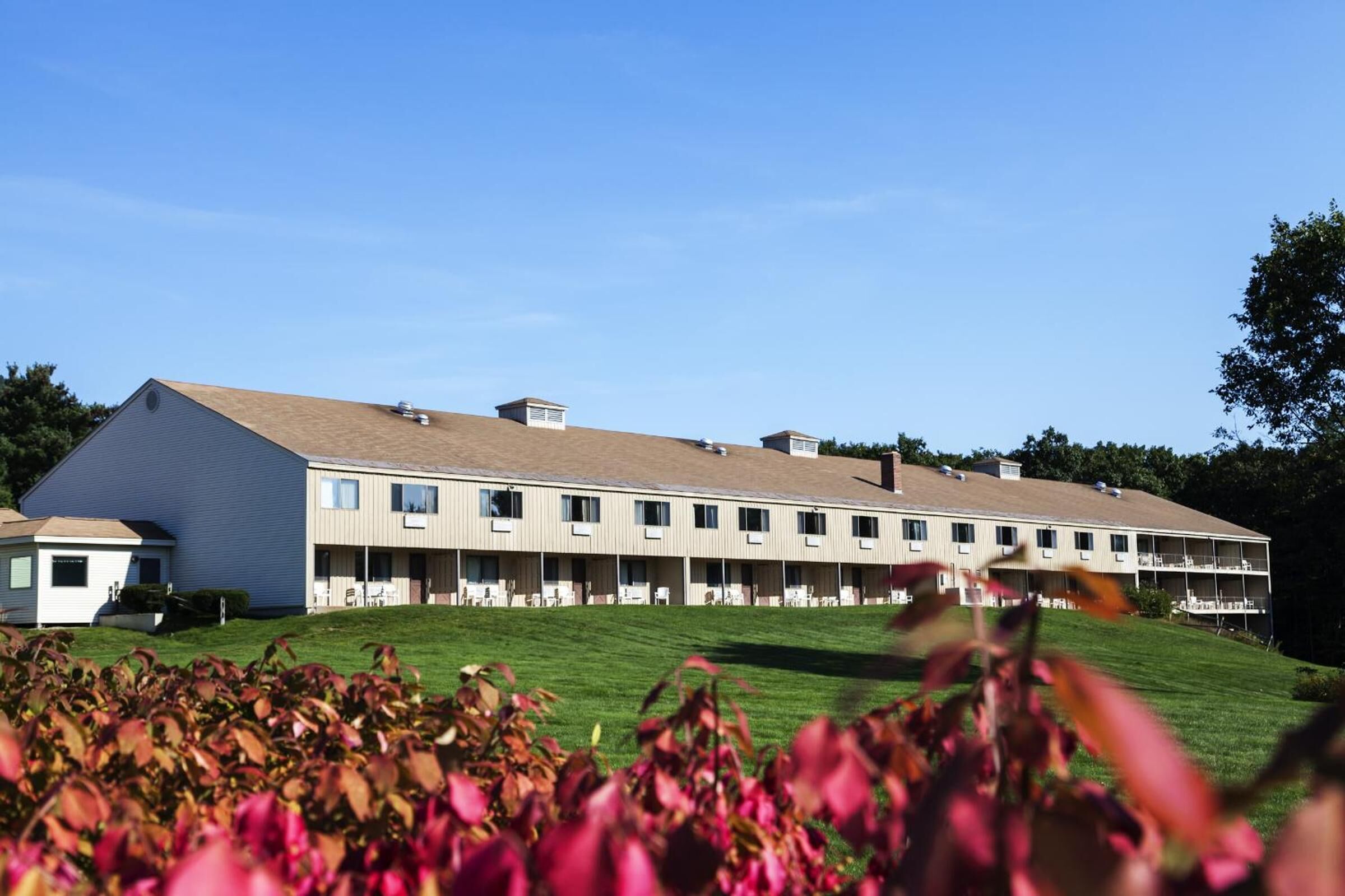 A multi-story motel with a flat roof and a row of windows on the ground floor.
