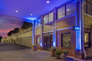 A hotel lobby with a 'Lobby' sign, large windows, and potted plants. - Best Western Fort Lee (Fort Lee)
