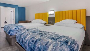 A hotel room with two beds, each with a white headboard and a blue and white patterned bedspread. - Hotel Blue 66, BW Signature Collection (Santa Rosa)