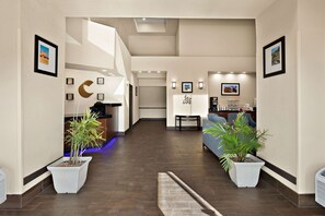 A spacious hotel lobby with a modern design, featuring a reception desk, seating area, and potted plants. - Comfort Suites University Las Cruces (Las Cruces)