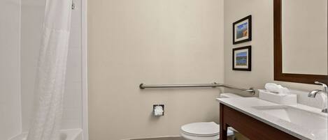 A bathroom with a shower, toilet, and sink.