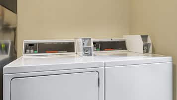 Una secadora comercial blanca con panel de control y una etiqueta que dice "Speed Queen Commercial Dryer".