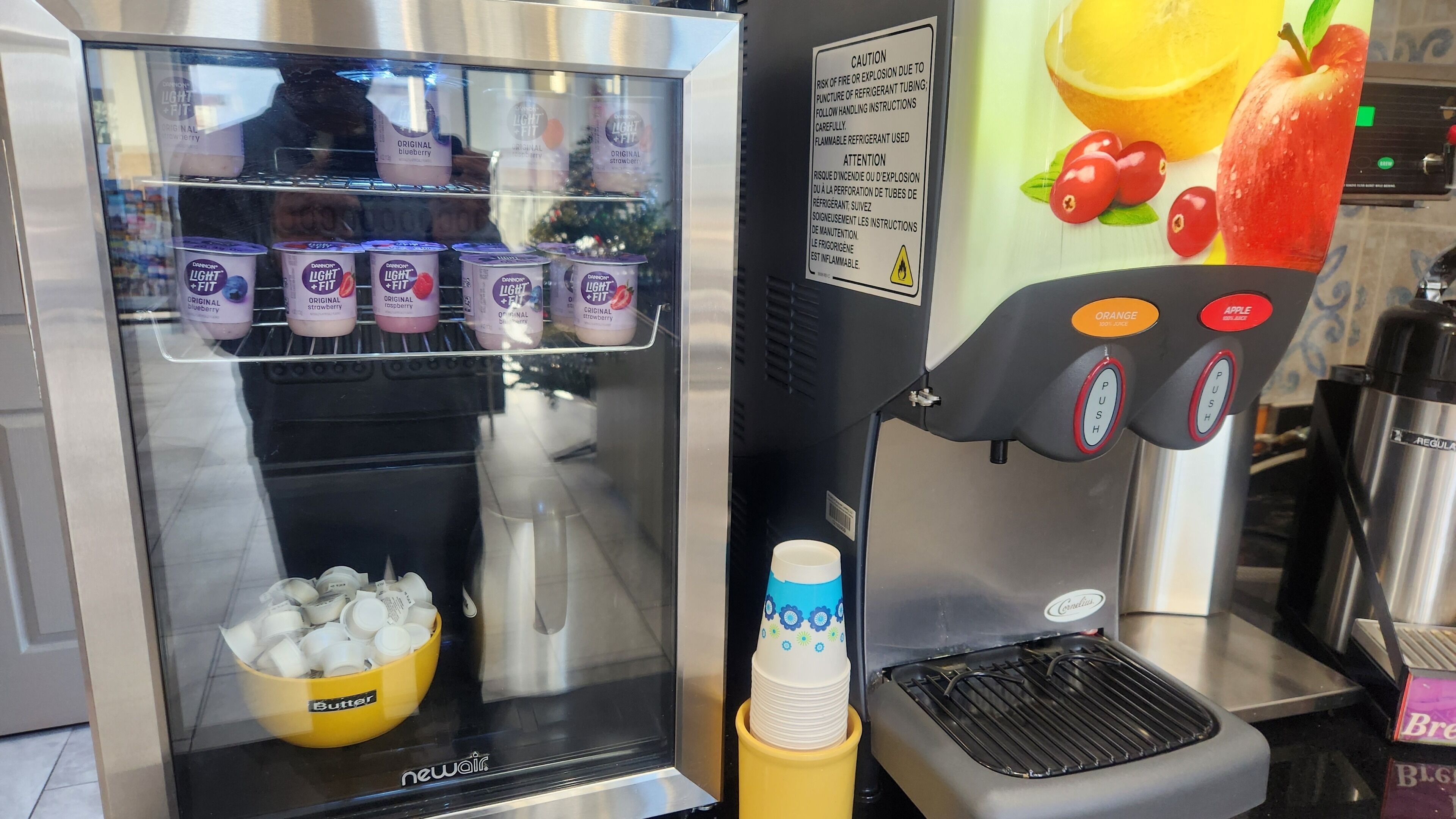 Un distributeur de boissons offrant plusieurs choix de breuvages, doté d’un bouton-poussoir pour la sélection et d’un compartiment pour les glaçons.