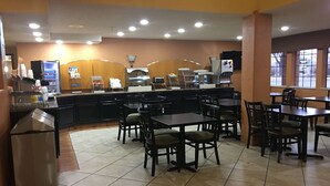 A restaurant with a counter, tables, and chairs. - Ramada by Wyndham Santa Fe (Santa Fe)