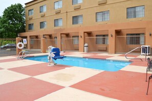 Una piscina al aire libre de temporada, tumbonas