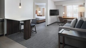 A hotel room with a kitchenette, a dining area, a living area with a sofa and TV, and a separate bedroom with a bed and window. - Residence Inn by Marriott Southern Pines/Pinehurst NC (Southern Pines)