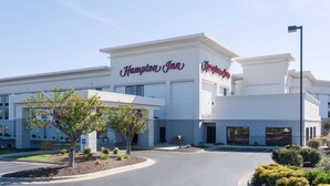Un hôtel Hampton Inn au design moderne, avec une grande enseigne, une entrée accueillante et des espaces paysagers aménagés.