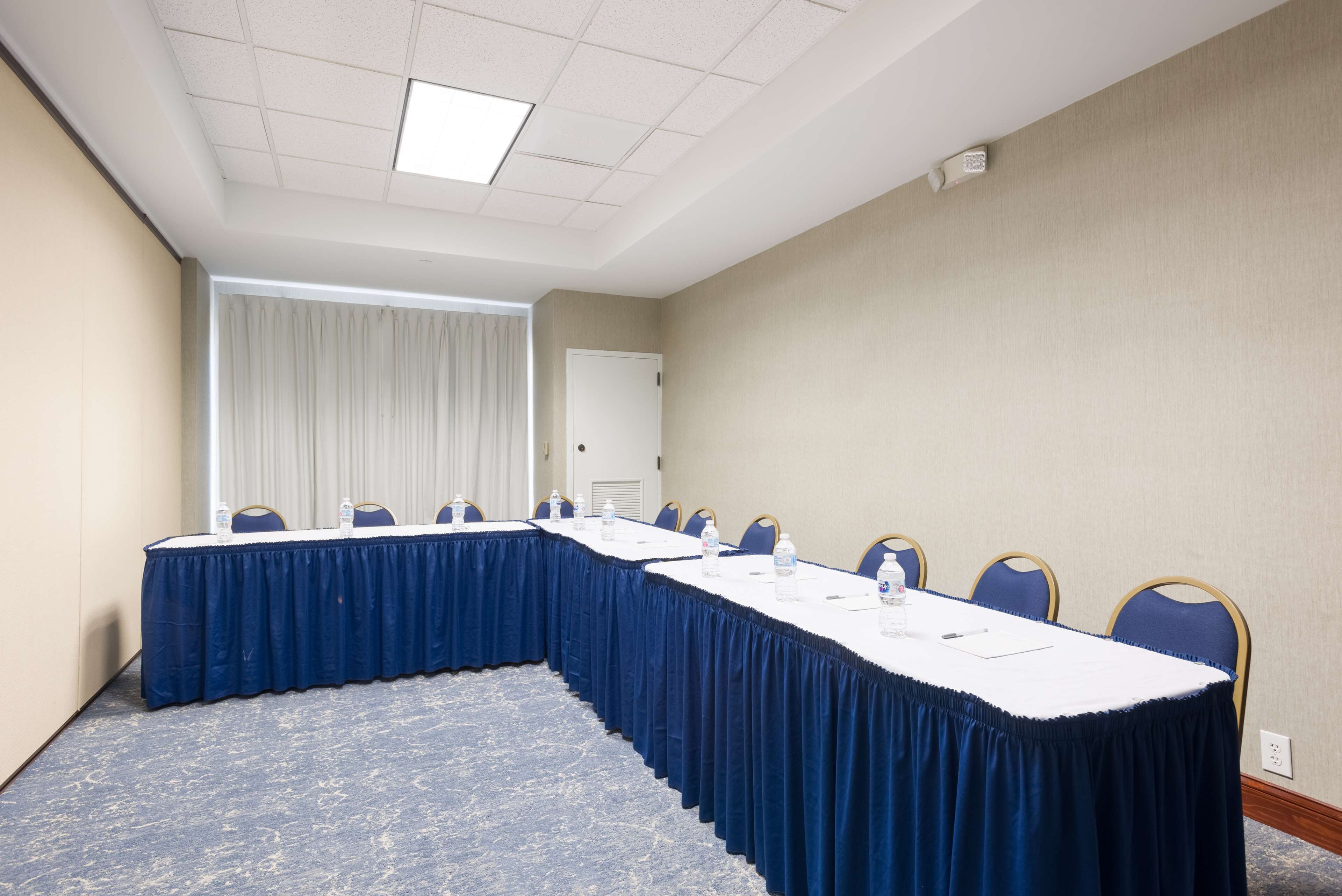A conference room with a long table, chairs, and a water dispenser.