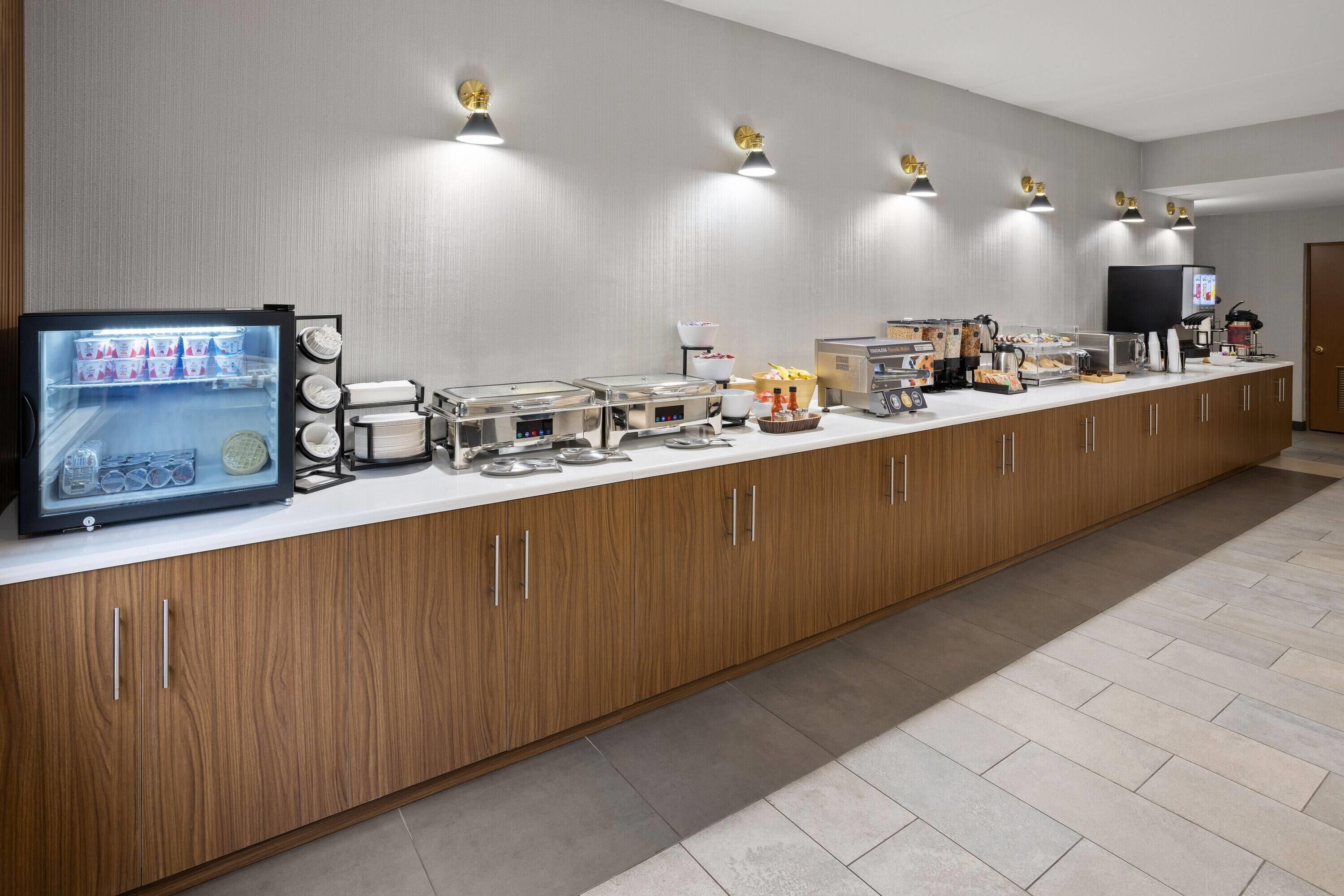 Een buffetopstelling met een gekoeld display, diverse eetstations en een televisiescherm.