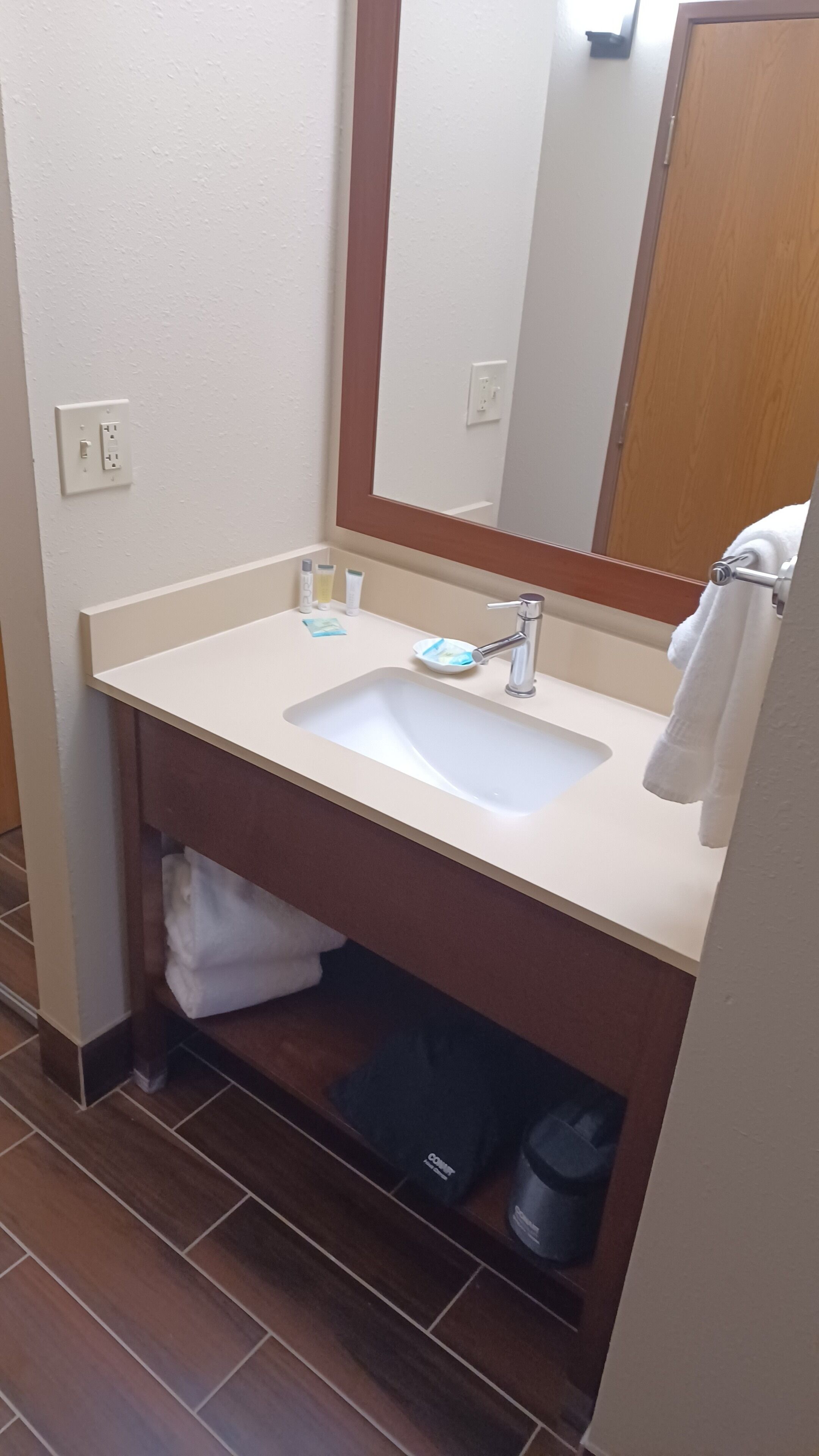 A bathroom with a white sink, a mirror, and a towel rack.