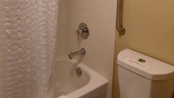 A bathroom with a bathtub, toilet, and shower.