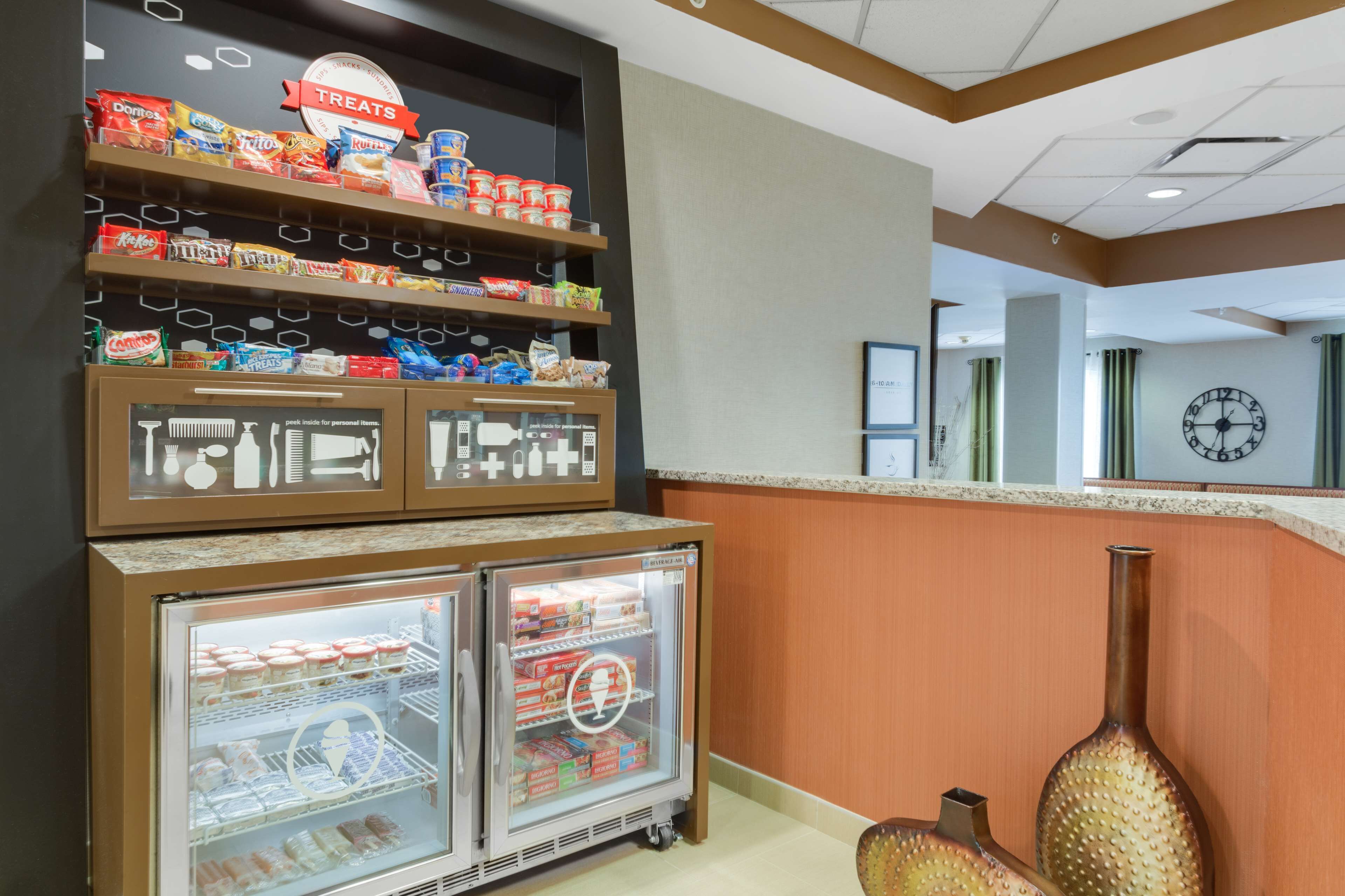 A snack display with various packaged foods and a refrigerated section with ice cream.