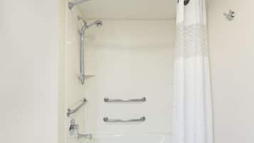 Een douche met een gebogen douchekop, handgrepen en een witte douchegordijn.